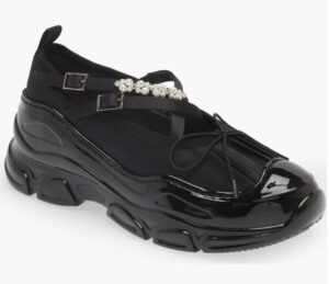 A sculptural women’s shoe by Simone Rocha featuring thick, tracker-style sole and delicate crisscross satin straps, blending utilitarian and romantic design elements